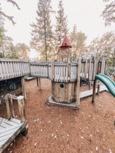 red topped wooden playground tower with chunky base shaped like a lighthouse.