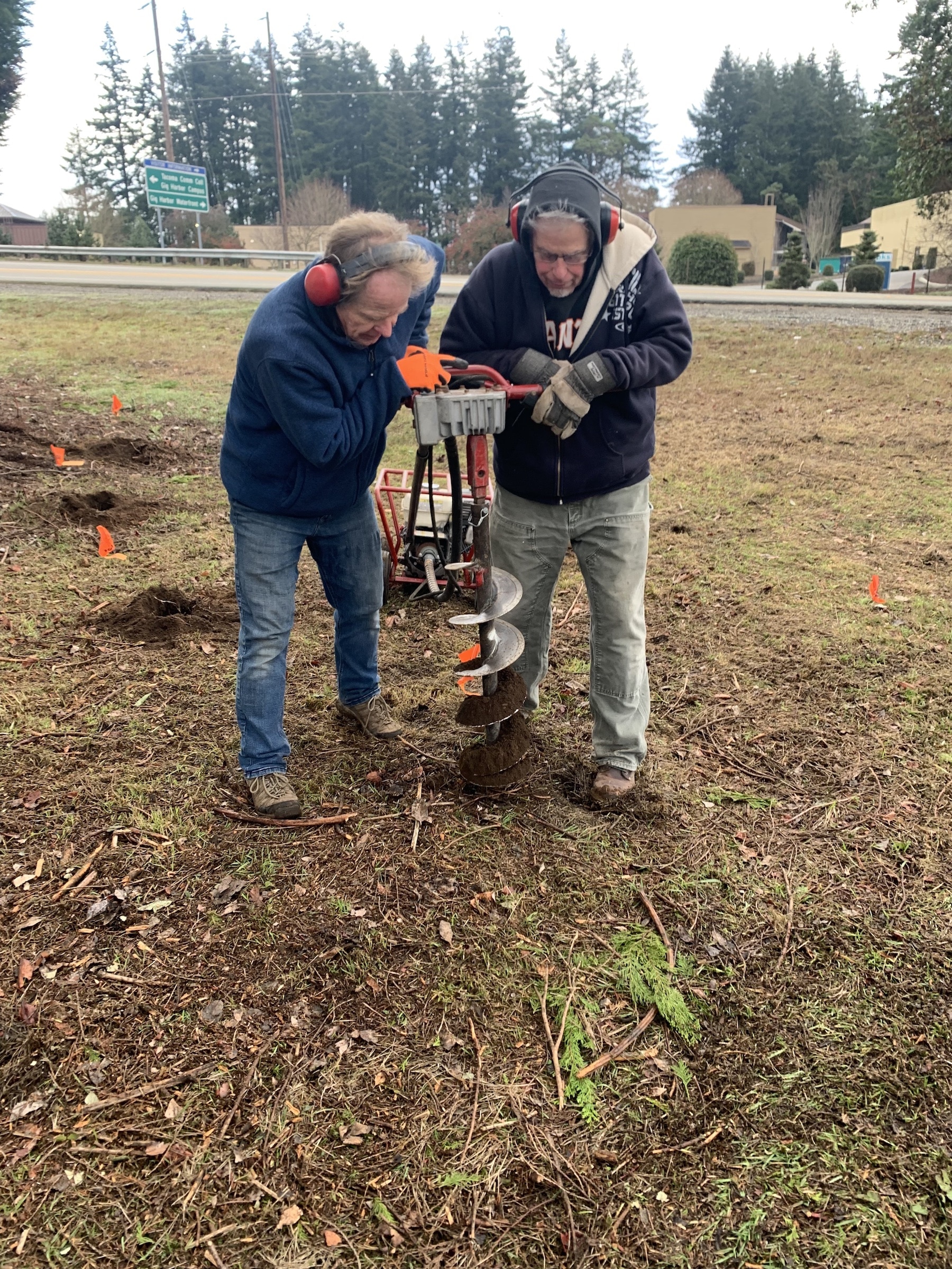 David Bacon and Kal Simmons dig holes with a power auger.