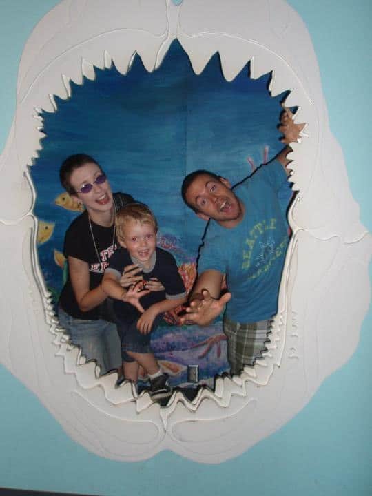 family posing with fake shark mouth