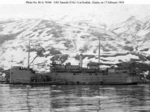 Black and white photo of Naval ship in Alaskan waters with a white snowy mountain behind it