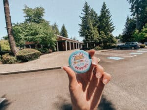 A round button in focus with a brick library building in the background