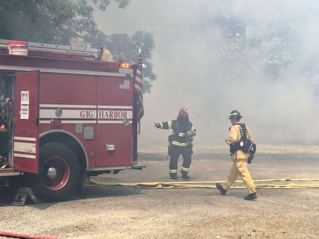 Firefighters string hoses near Peninsula Lutheran Church.