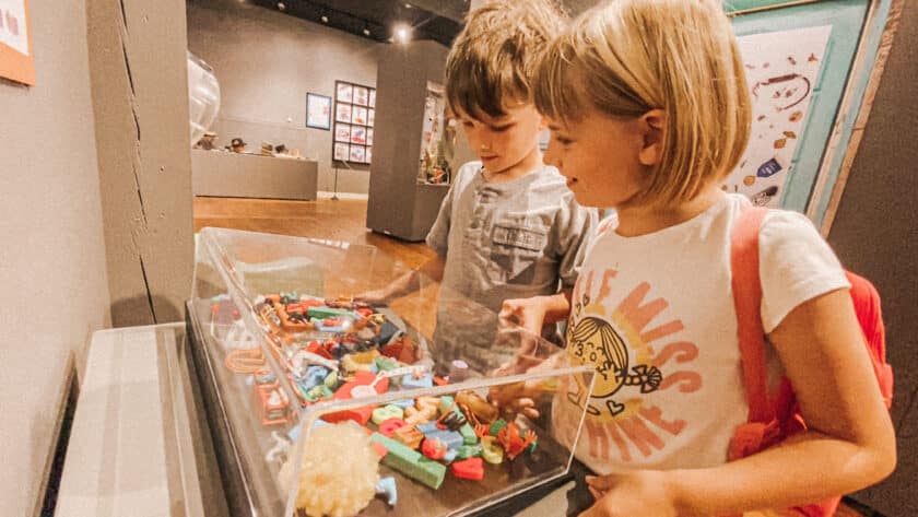 boy and girl in a museum looking at trinkets behind glass