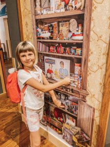 Girl pointing to toys in poster