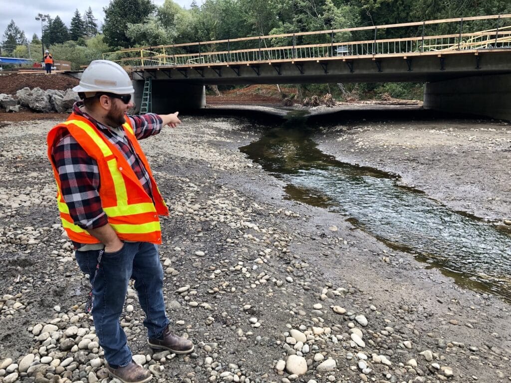 Project engineer Justin Janke, on the lagoon side of the bridge, describes how the streambed was built to keep the creek on the surface. The area fills up with seawater during high tides.