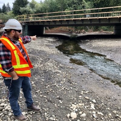 Project engineer Justin Janke, on the lagoon side of the bridge, describes how the streambed was built to keep the creek on the surface. The area fills up with seawater during high tides.