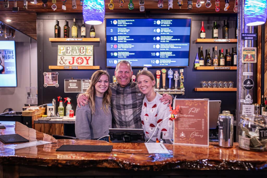Owner Hal Haase with two of his daughters Hilari, right, and Ciera, left, behind the bar.