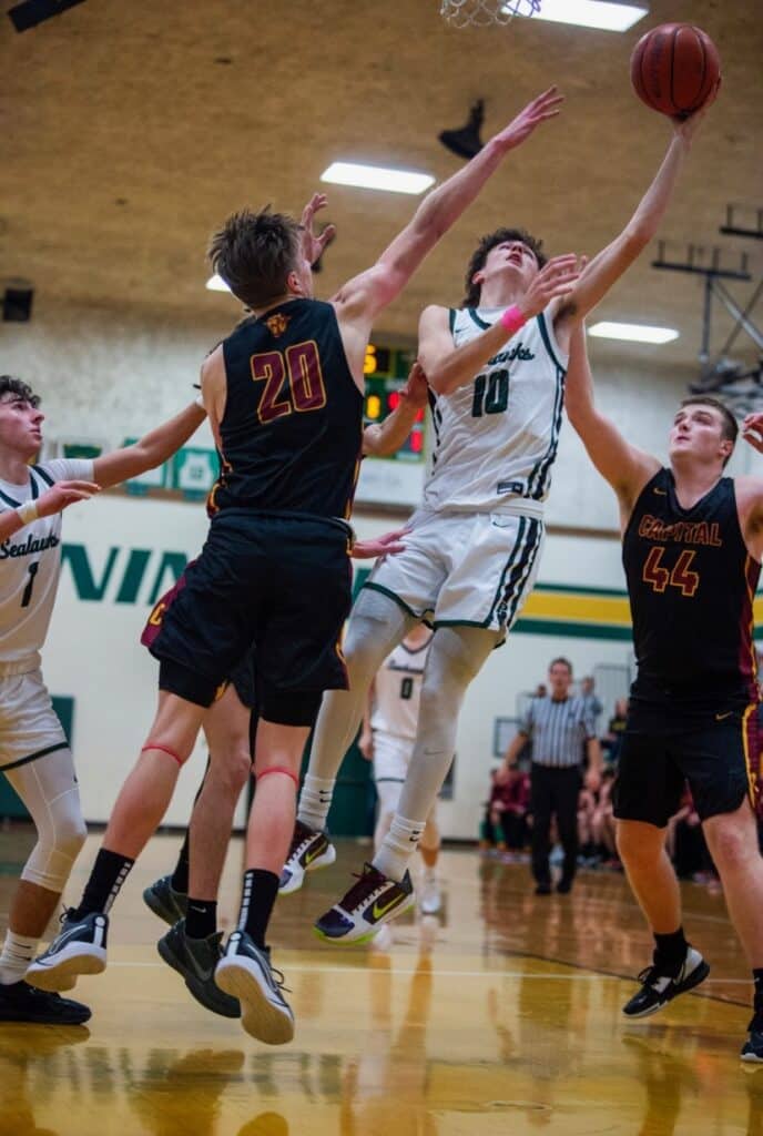 Seahawks leading scorer Issac Schultz-Tate slices between Capital defenders for a deuce in a Peninsula win.