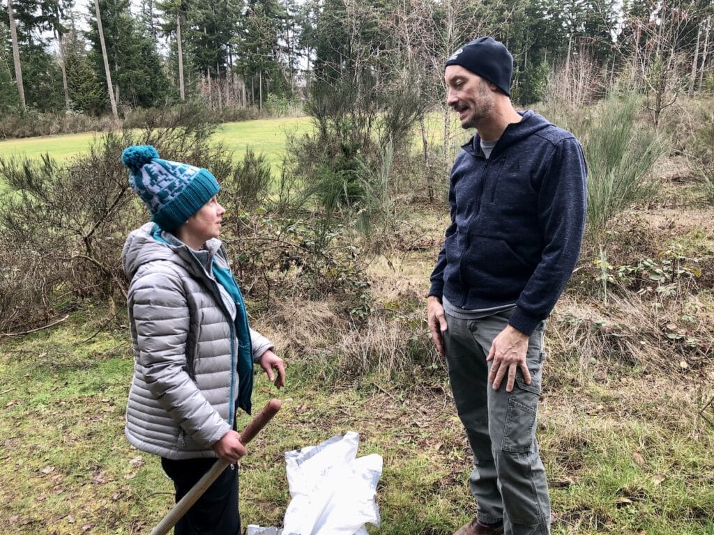 Pacific Lutheran biology professor Michael Behrens helps Jaime Hughes-Crosbie identify her plants. Behrens is on the Gig Harbor Land Conservation Fund board.