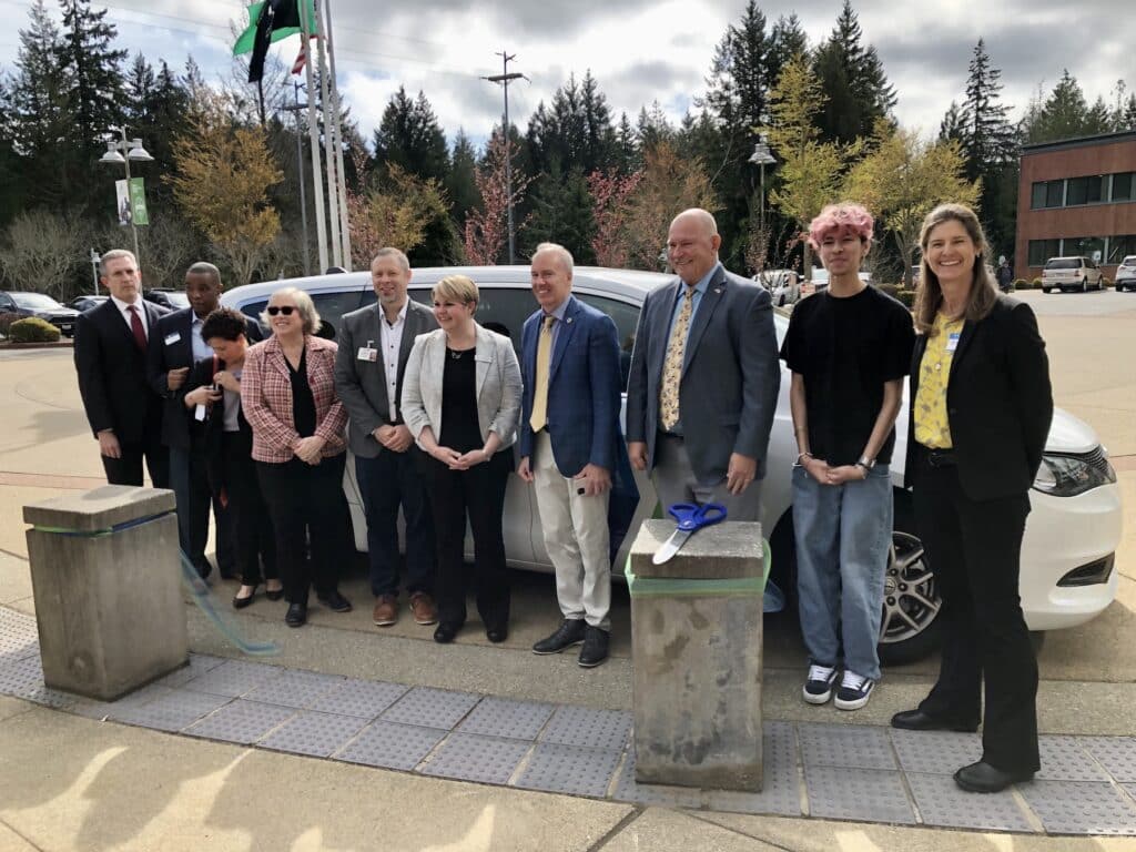 The ribbon cutters in front of a Runner van.